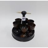 Set of six wooden egg cups on a circular stand with bone handle, (6)
