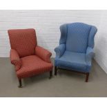 Wing armchair with blue fabric upholstery and together with a red upholstered armchair with mahogany