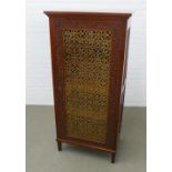 Mahogany & hardwood cabinet with a single glazed door having a trellis design enclosed by a carved