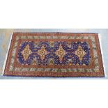 Eastern rug, blue field with four flowerhead medallions, floral and hooked borders, 185 x 89cm