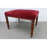 Red velvet upholstered stool of large proportions on turned mahogany legs. 47 x 68 x 58cm.