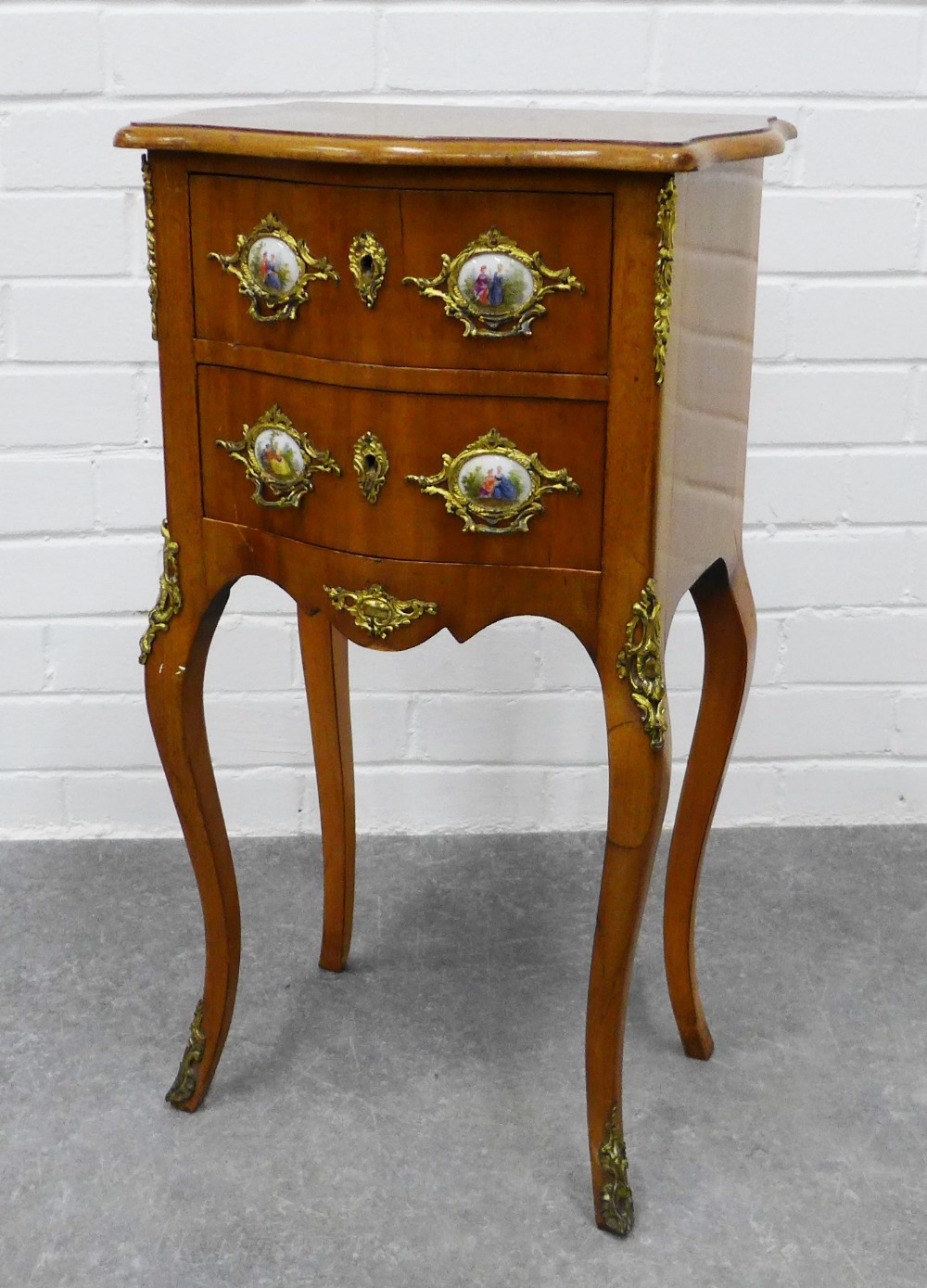 French style mahogany serpentine cabinet, two drawers with ormolu and porcelain mounts, on