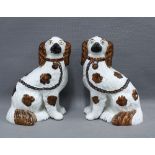 A pair of Staffordshire chimney spaniels with painted faces and copper lustre patches, 24cm, (2)