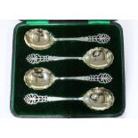 Cased set of four silver gilt serving spoons, with pierced anthemion terminals and shaped bowls,