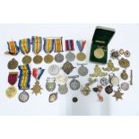 A collection of WWI & WWII medals, cap badges and commemorative coins, John Pinches silver gilt