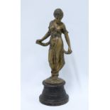 Bronzed metal female figure on a circular iron base, 30cm