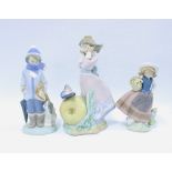 Three Lladro figures to include a girl in front of an apple and butterfly, (3) 23cm.