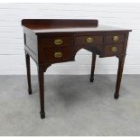 Mahogany ledge back desk with five drawers, brass handles and square tapering legs with spade feet .