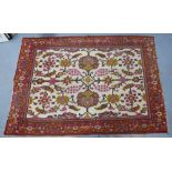 Persian rug, ivory field with flowers and foliage within a red border, 265 x 185cm