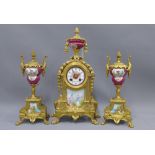 Gilt metal and porcelain clock garniture, the clock with urn surmount and ceramic dial with