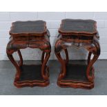 A pair of red lacquered chinoiserie side tables, of stylised form with conforming under tier,