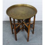 Benares table with brass tray top and folding wooden base, 51cm diameter