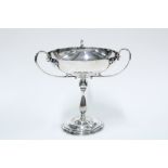 George V silver comport, the raised bowl with three looping handles on a baluster stem and spreading