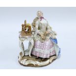 19th century porcelain figure of a woman sat in a high back chair beside a spinning wheel, blue