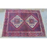 Kazak rug, red field. with two ivory lozenge and a flowerhead border 204 x 150cm. (a/f)