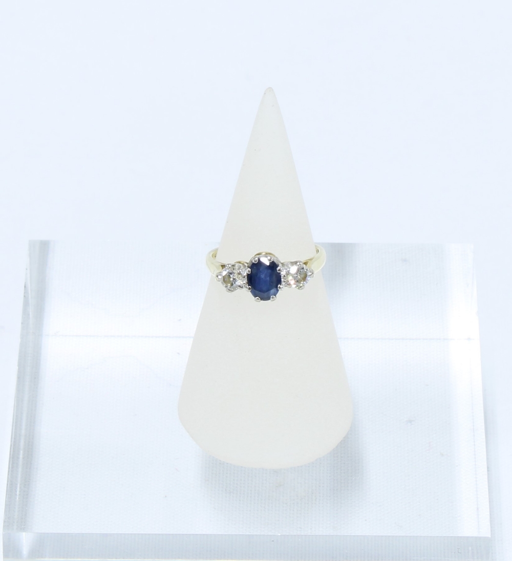 Sapphire and diamond three stone ring, the central oval cut sapphire of approx. 0.75ct flanked by