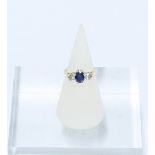 Sapphire and diamond three stone ring, the central oval cut sapphire of approx. 0.75ct flanked by