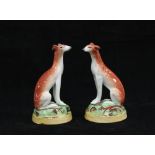 Pair of 19th century Staffordshire hounds on circular bases, (2) 10cm.