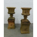 Pair of fireclay garden urns, campana form with acanthus leaf detail, on rectangular plinths . 93