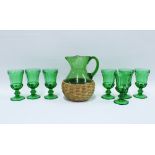 Green glass lemonade / water set comprising a jug with basket cover an set of seven goblet style