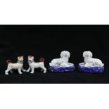 Pair of porcelain dog and pup figure groups, on blue cushions bearing gold anchor backstamps,