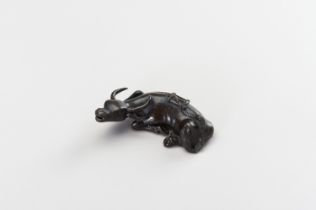 A CHINESE BRONZE FIGURE OF A TAMED WATER BUFFALO