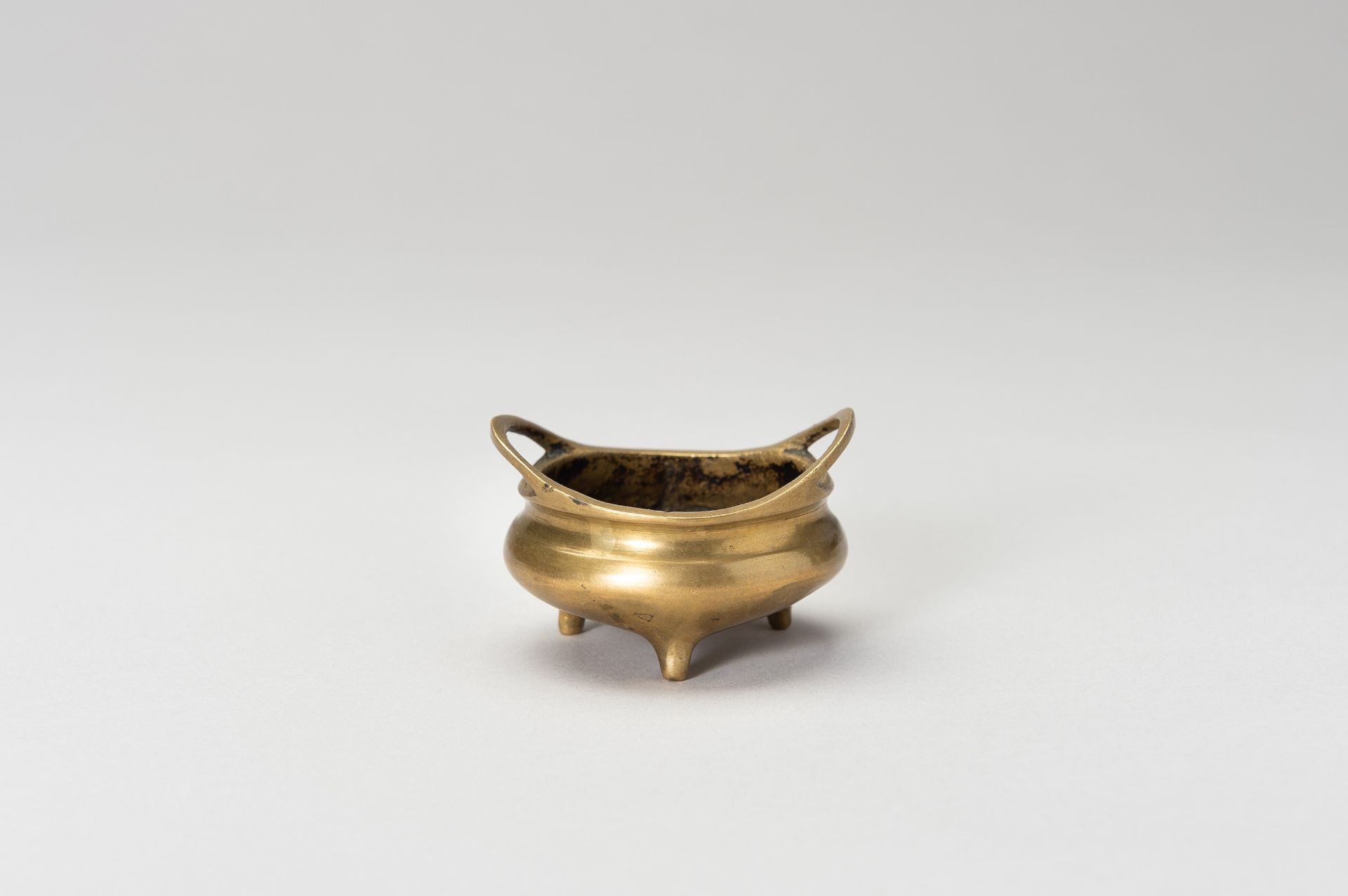 A MINIATURE BRONZE TRIPOD CENSER