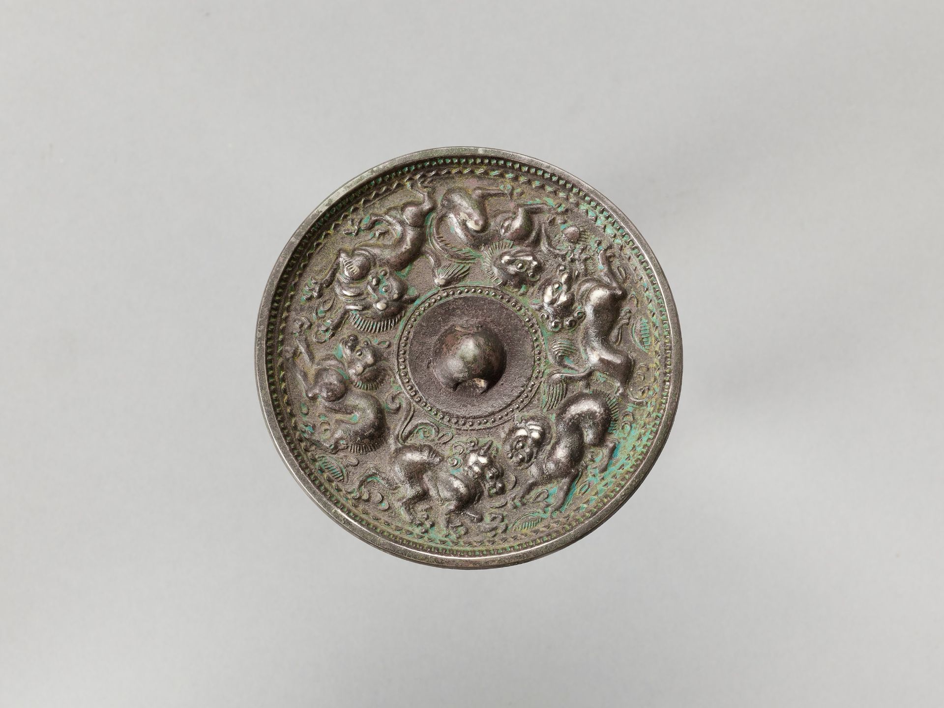 A CIRCULAR BRONZE MIRROR WITH ANIMALS