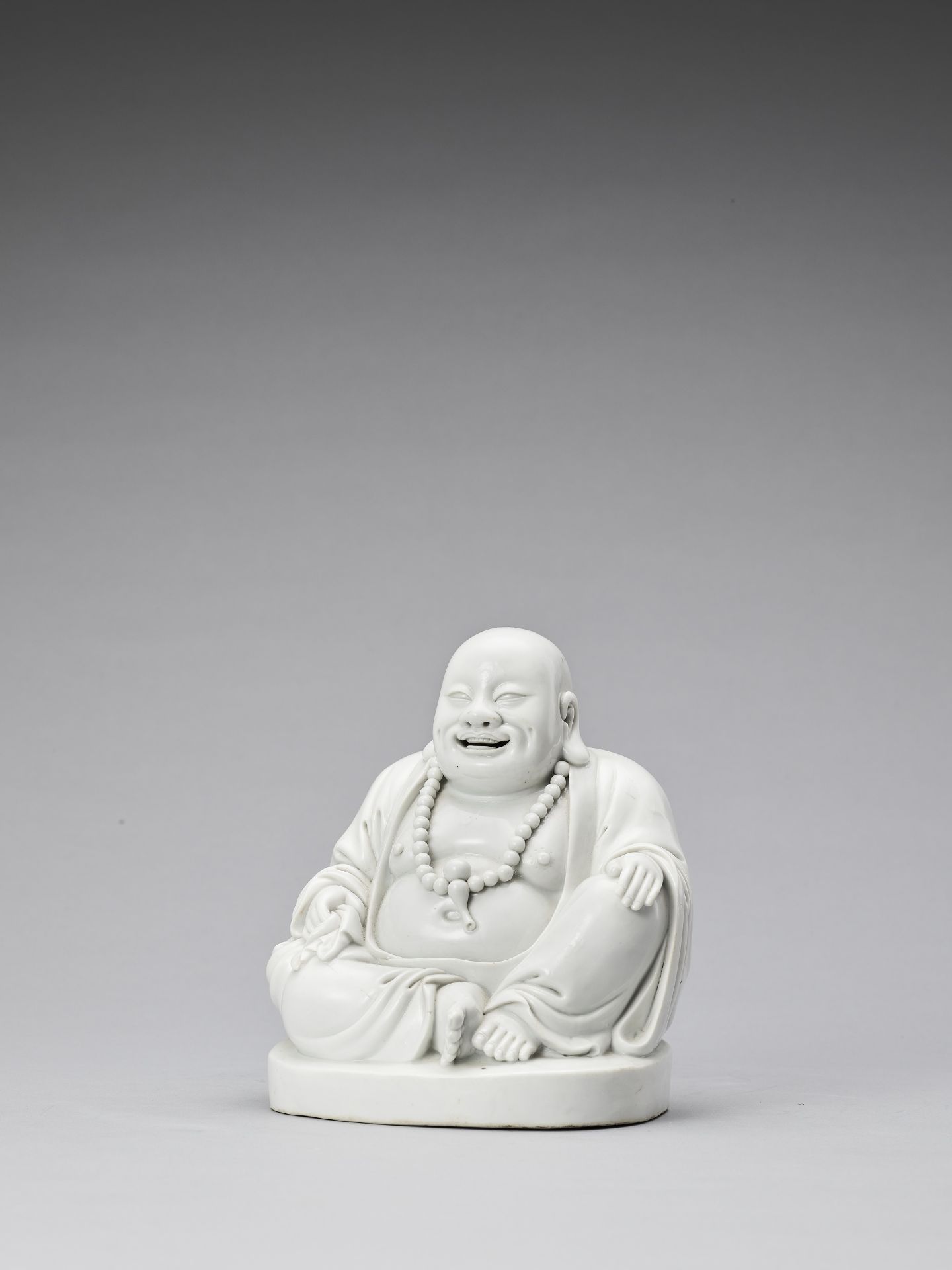 A WHITE GLAZED DEHUA PORCELAIN FIGURE OF BUDAI, QING - Bild 3 aus 7