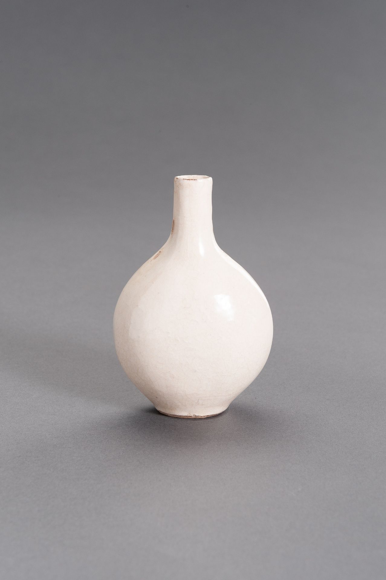 A MOLDED AND CREAM-GLAZED CERAMIC FLASK, MING DYNASTY