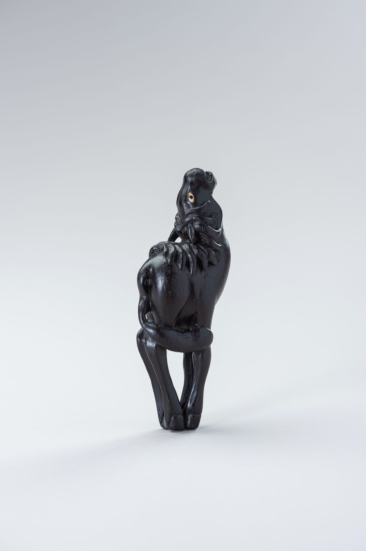 A LARGE EBONY WOOD NETSUKE OF A BAYING HORSE