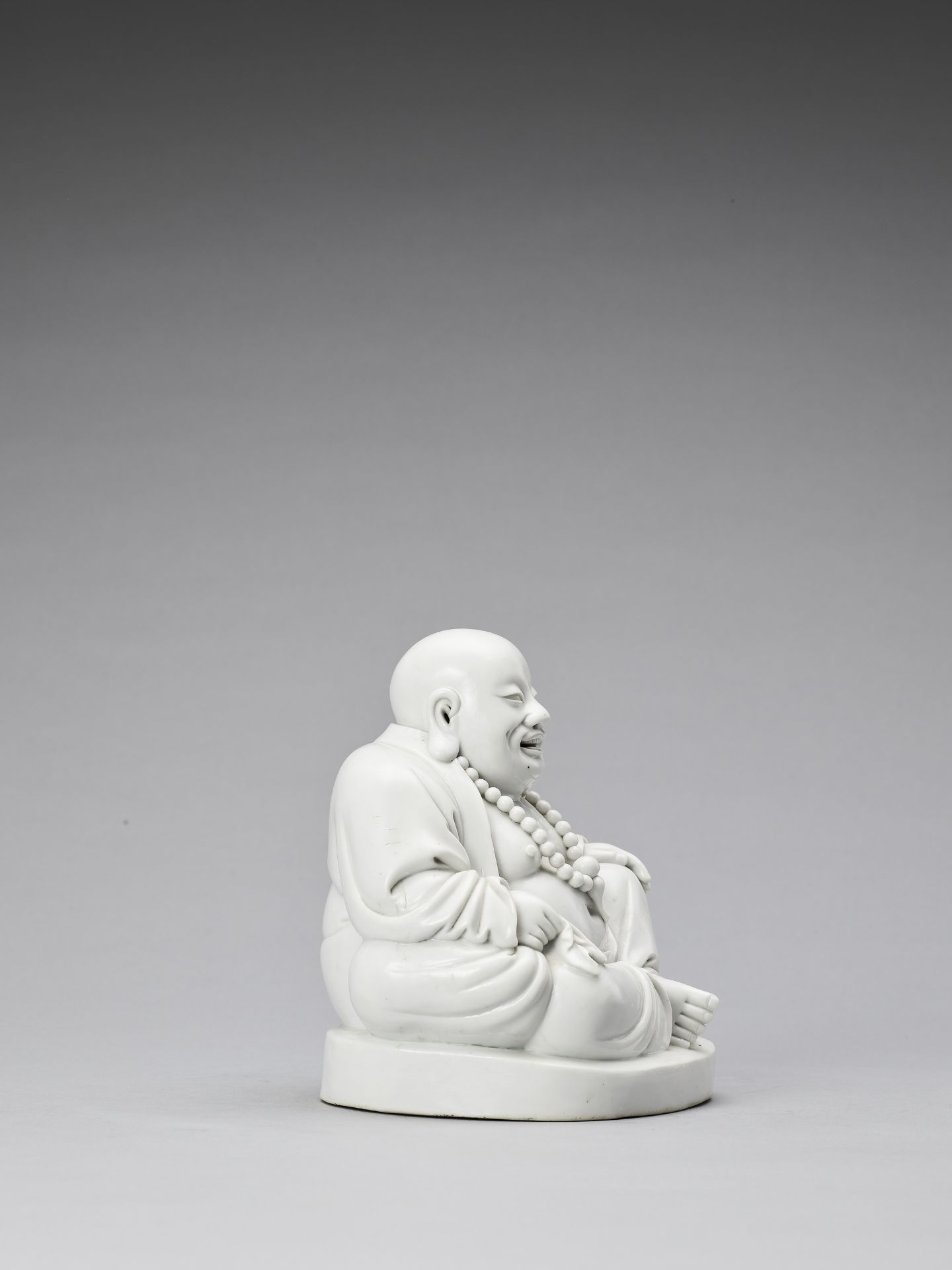 A WHITE GLAZED DEHUA PORCELAIN FIGURE OF BUDAI, QING - Bild 6 aus 7