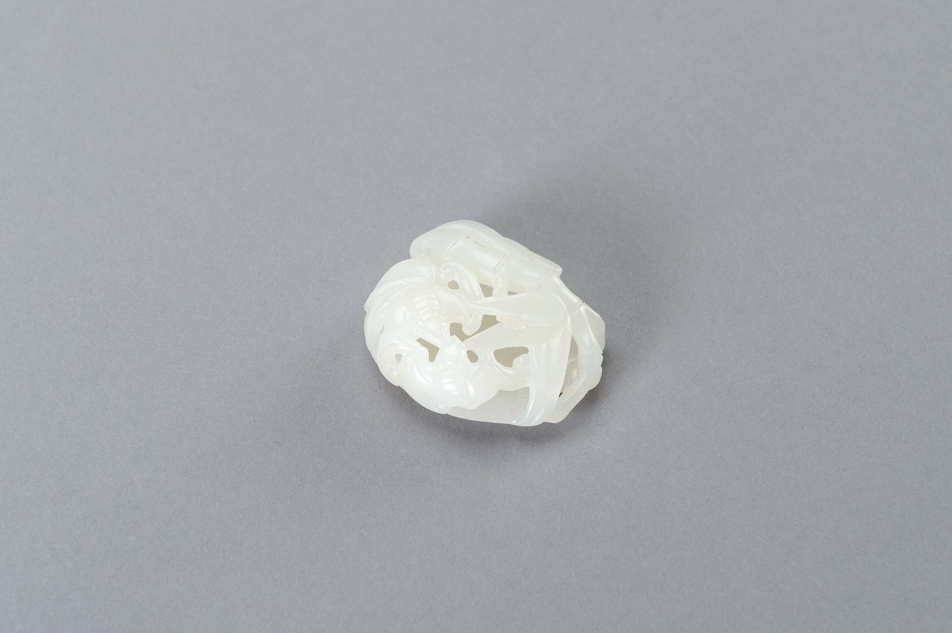 A RETICULATED WHITE JADE PENDANT WITH BATS AND BAMBOO