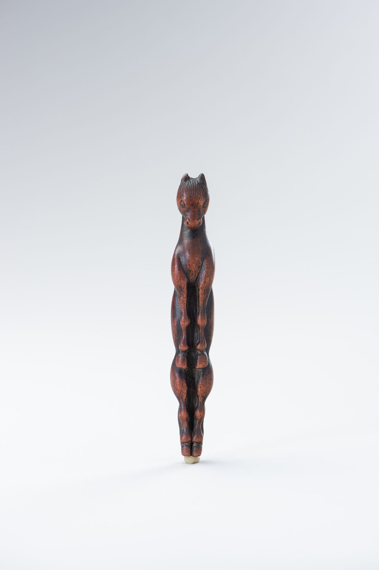 A WOOD OBIHASAMI NETSUKE IN THE SHAPE OF A HORSE