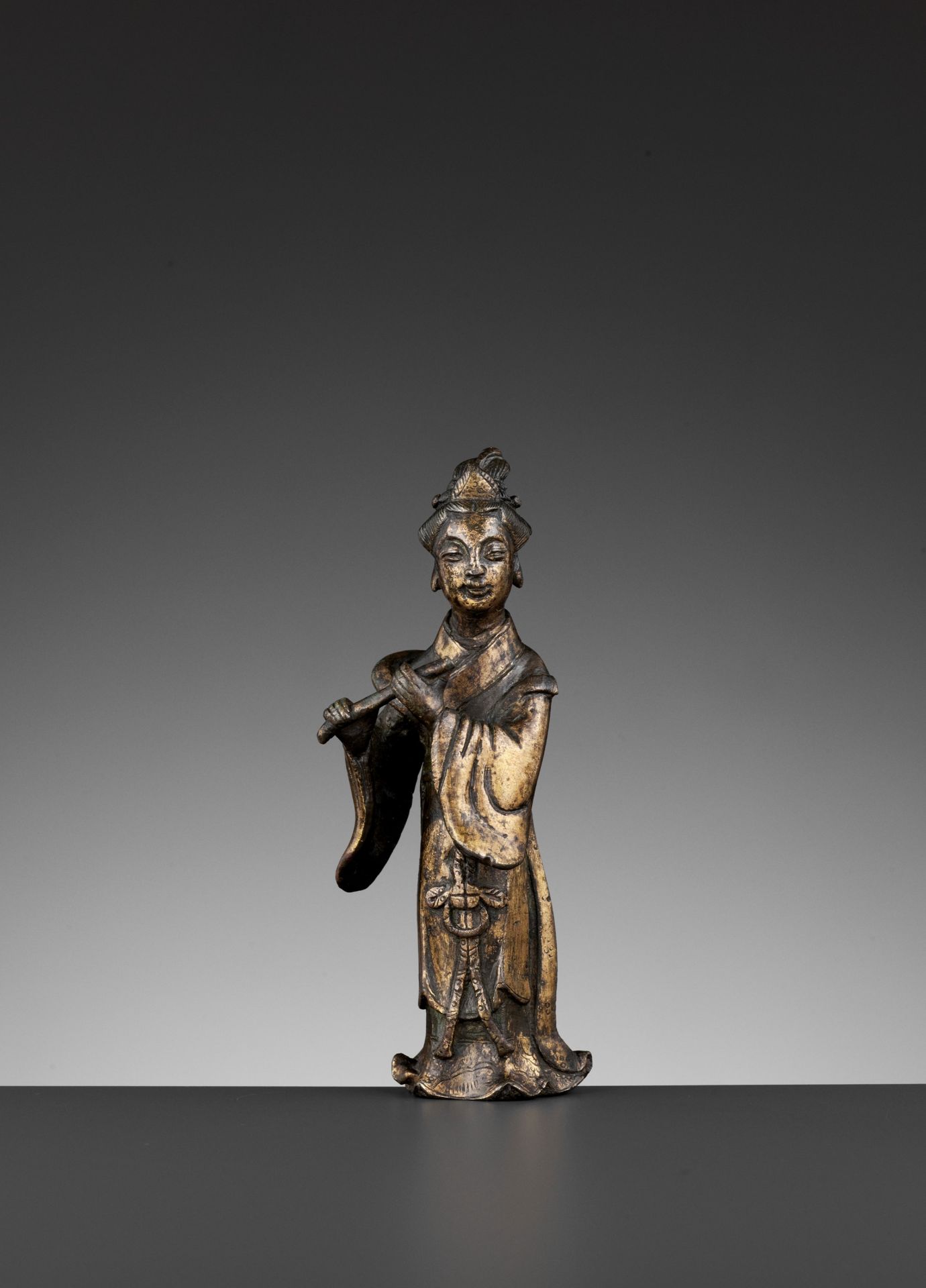 A PARCEL-GILT BRONZE FIGURE OF A FLUTIST, SONG TO MING DYNASTY