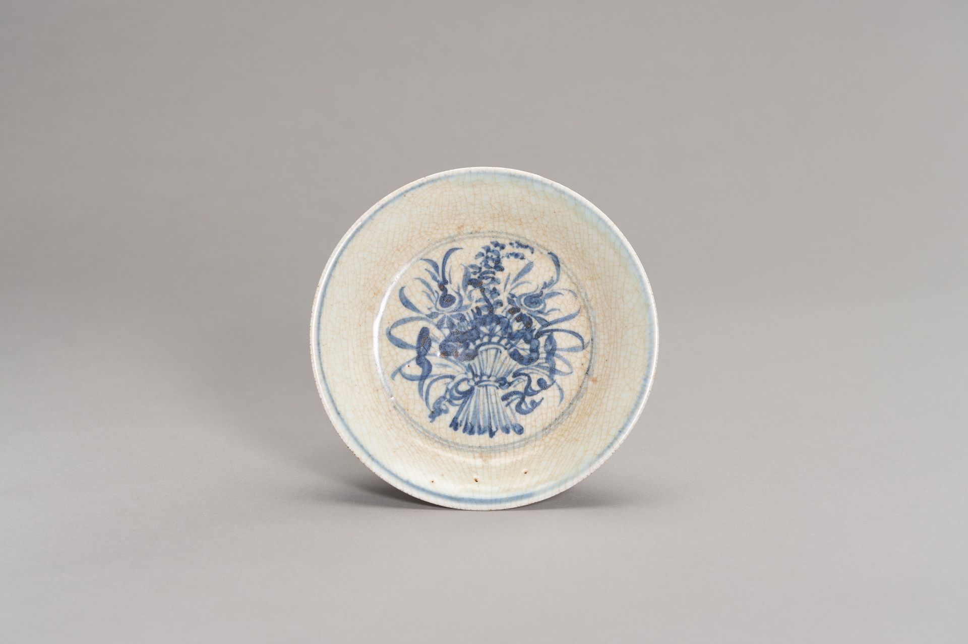 A CELADON AND BLUE DISH WITH A FLOWER BOUQUET