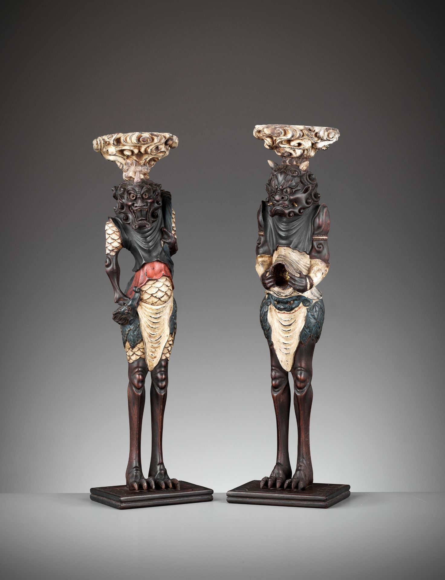 A PAIR OF PAINTED AND LACQUERED WOOD FIGURAL CANDLESTICKS DEPICTING ONI