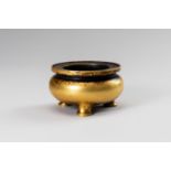 A SMALL GILT-BRONZE TRIPOD CENSER