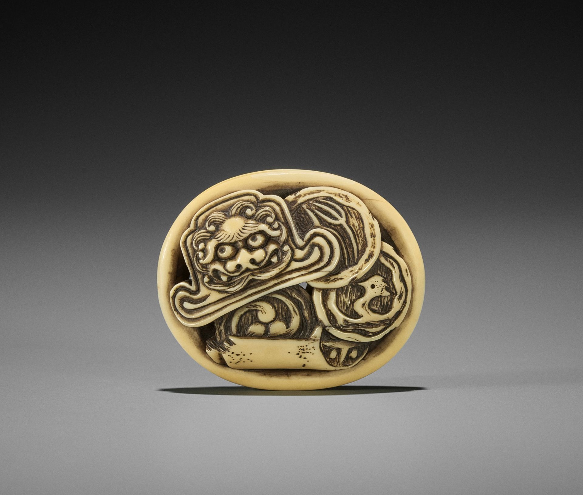 EISAI: A WALRUS IVORY RYUSA MANJU NETSUKE OF ONIGAWARA