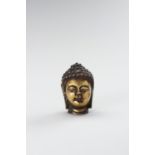 A MINIATURE GILT-BRONZE BUDDHA HEAD