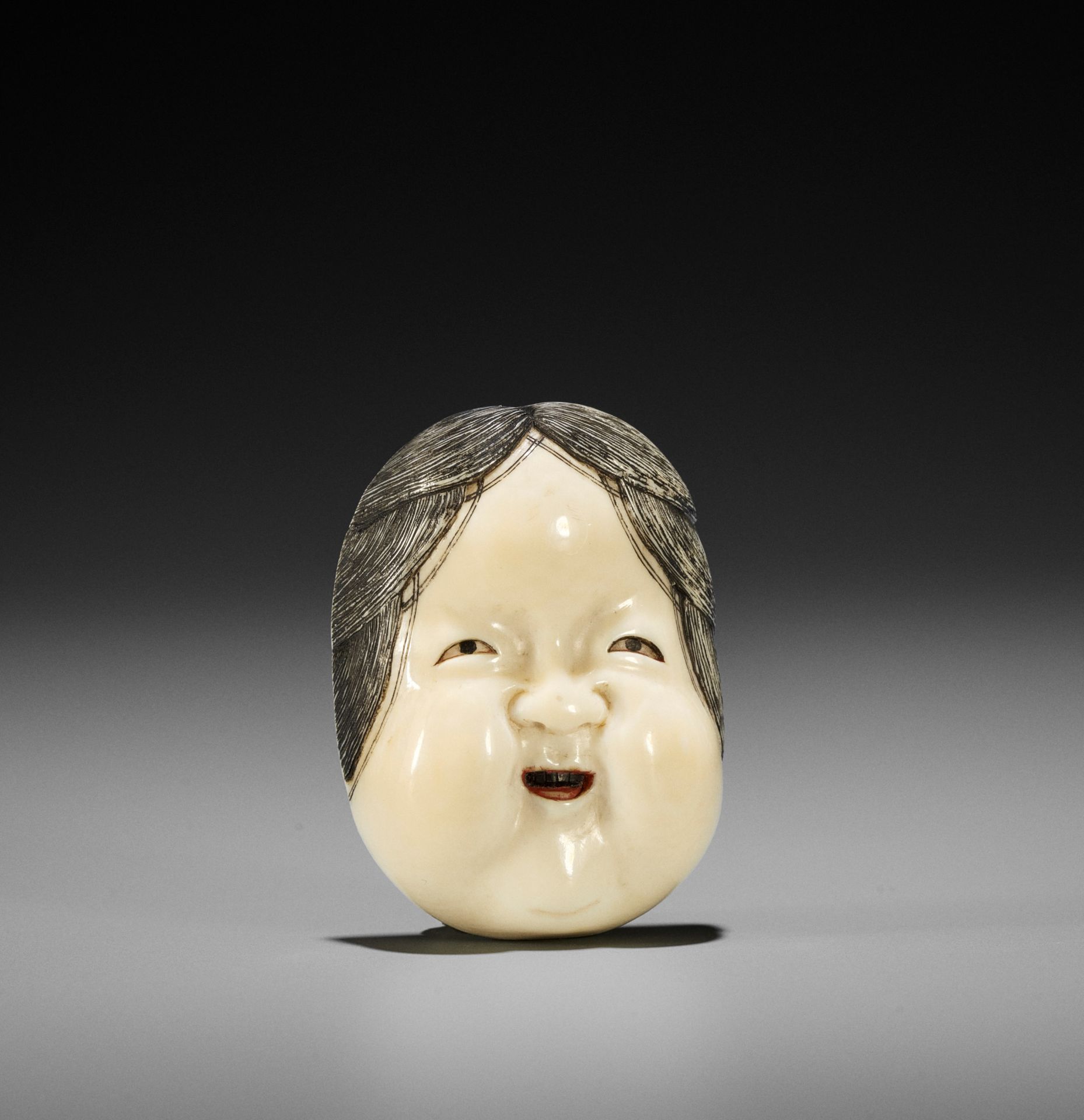 KOGYOKU: A FINE IVORY MASK NETSUKE OF OKAME