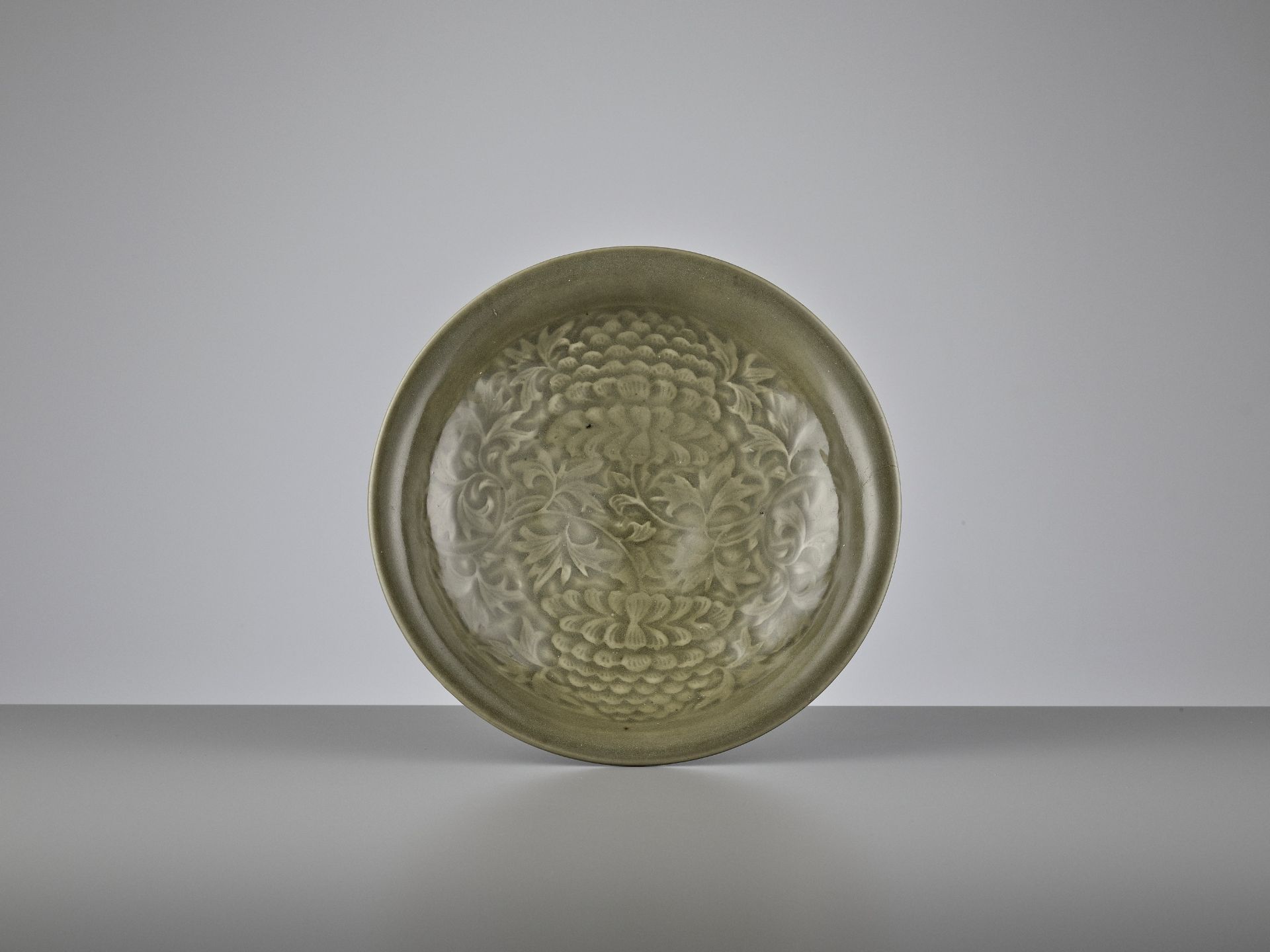 A YAOZHOU CELADON CARVED 'PEONY' SHALLOW BOWL, NOTHERN SONG DYNASTY