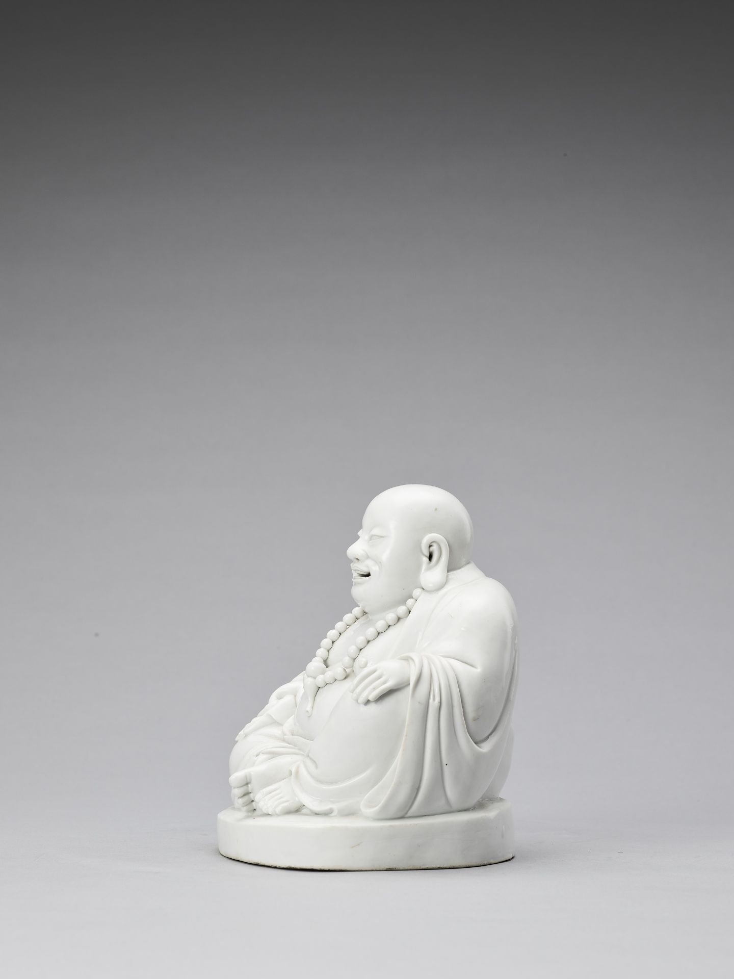 A WHITE GLAZED DEHUA PORCELAIN FIGURE OF BUDAI, QING - Bild 4 aus 7