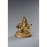 A TIBETAN GILT BRONZE FIGURE OF KUBERA WITH BUDDHIST LION