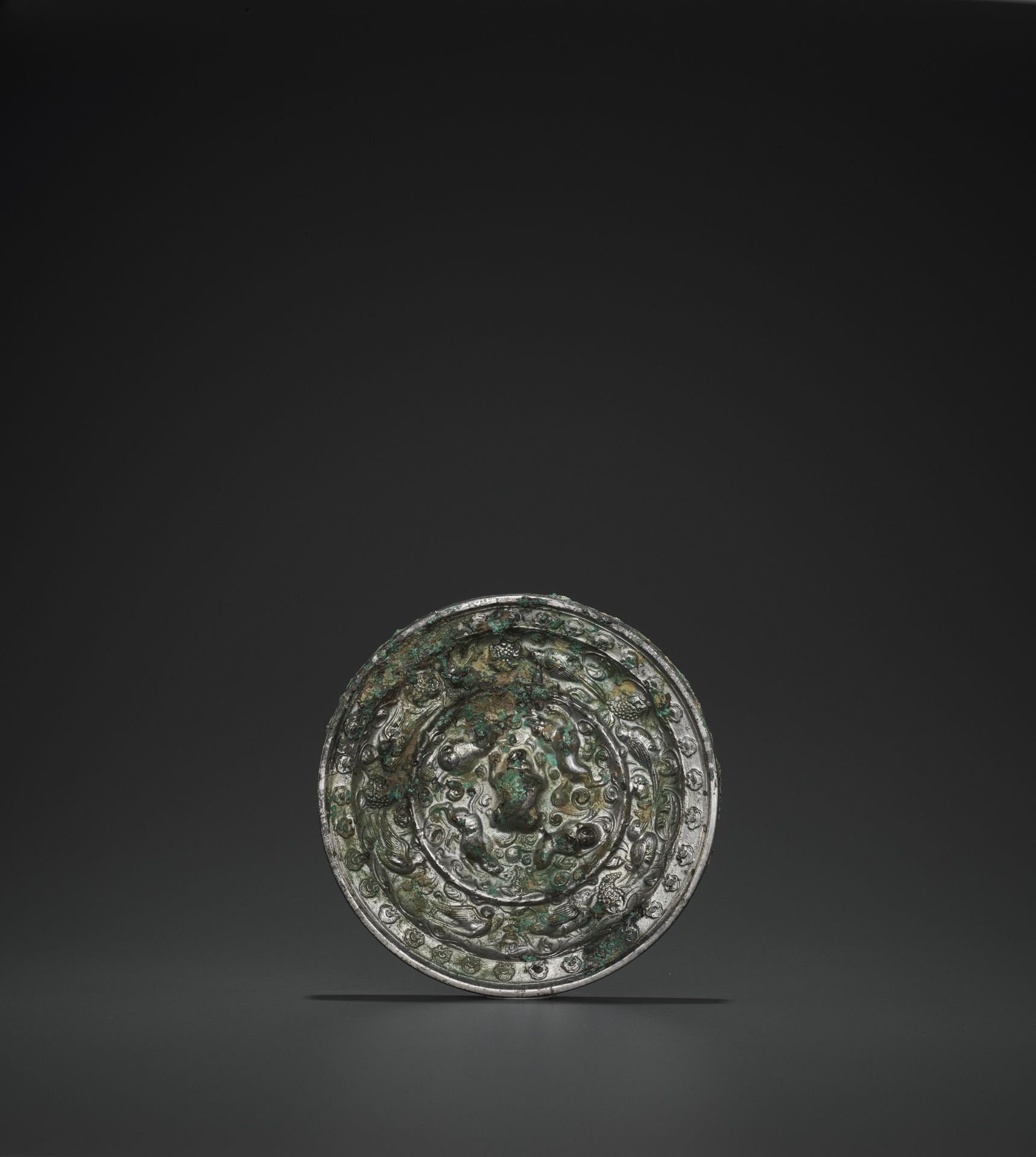 A RARE SILVERED BRONZE 'LIONS AND GRAPEVINES' MIRROR, TANG
