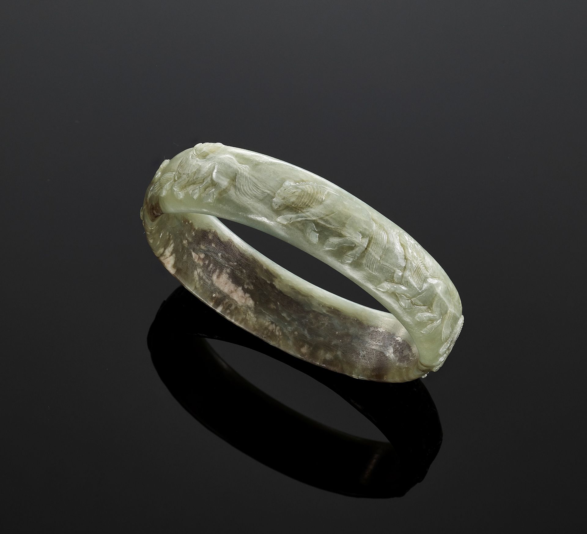 A CELADON JADE 'EIGHT HORSES OF MU WANG' BANGLE, QING DYNASTY