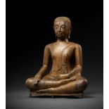 A RARE LACQUER-GILT BRONZE FIGURE OF AN ARHAT, AYUTTHAYA PERIOD