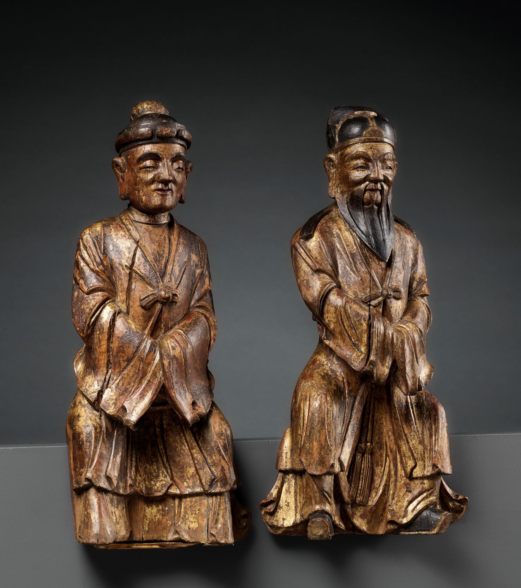 A PAIR OF GILT-LACQUERED HARDWOOD FIGURES OF DAOIST IMMORTALS, MING DYNASTY