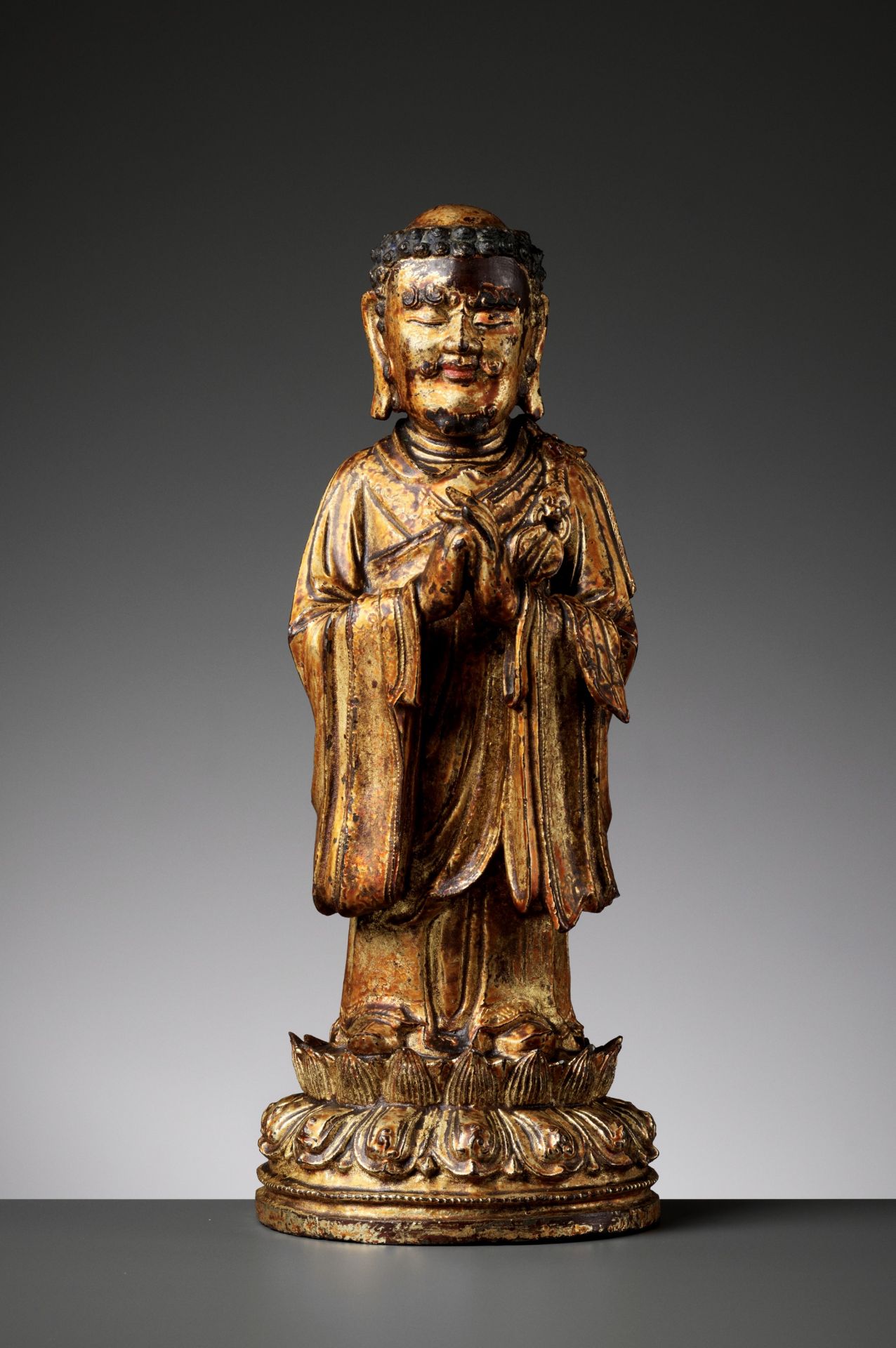 A RARE GILT BRONZE FIGURE OF A BUDDHIST DISCIPLE, POSSIBLY ANANDA, MING DYNASTY