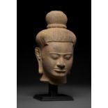 A LARGE SANDSTONE HEAD OF A MALE DEITY, BAPHUON STYLE, ANGKOR PERIOD